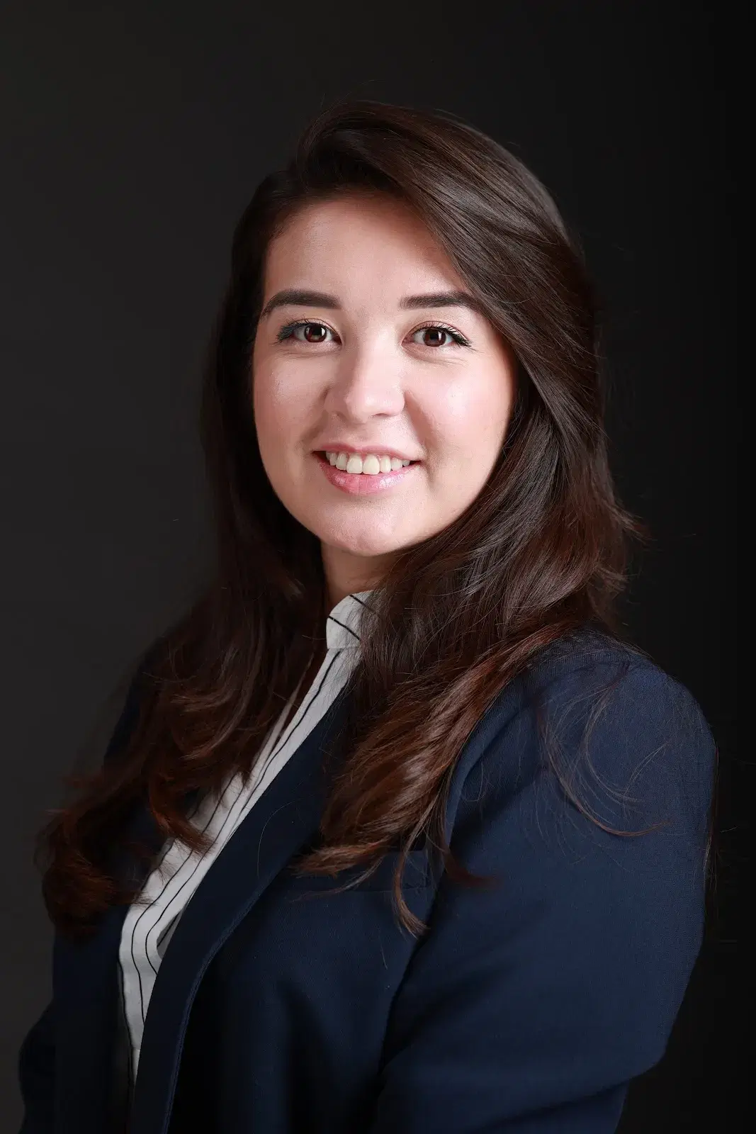 Professional headshot of a smiling woman in a navy blazer