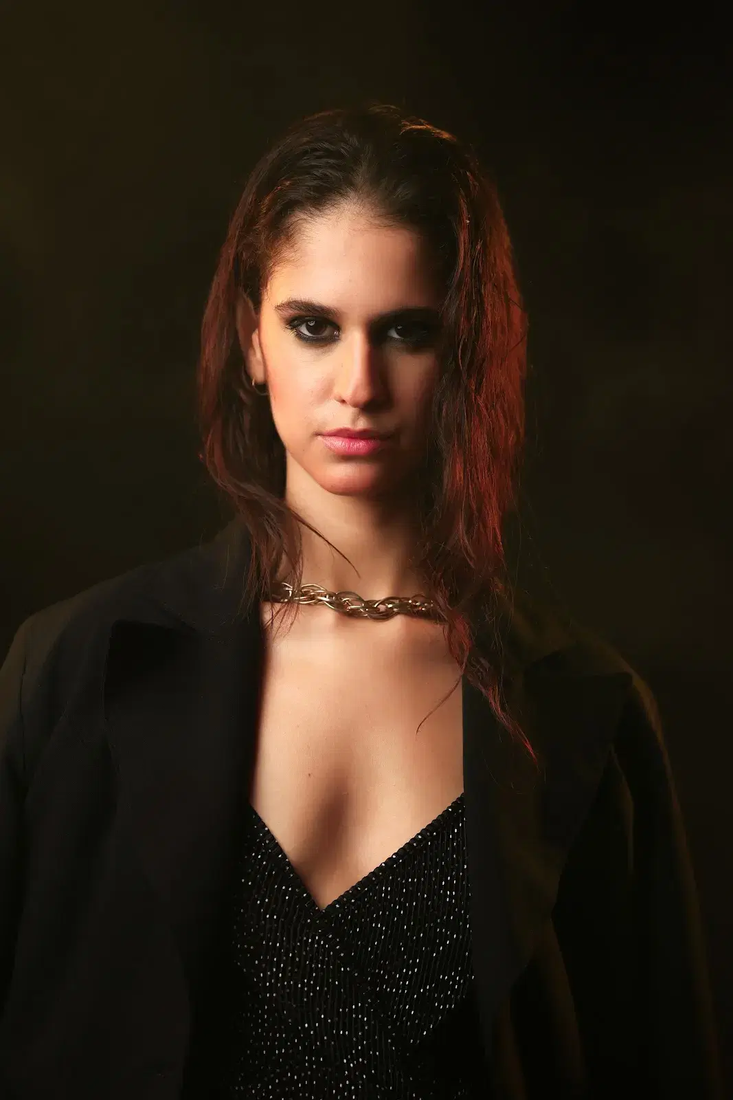 Dramatically lit editorial portrait in a black blazer
