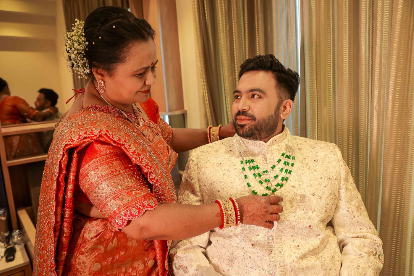 Groom being dressed by his mother before Riya and Aditya's wedding at W Goa